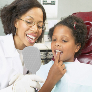 Girl with the Dentist - “ The dentist is examining the loose tooth.”