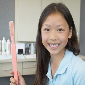 Girl with toothbrush - “We encourage your child to develop lifelong skills in taking care of her
teeth.” 